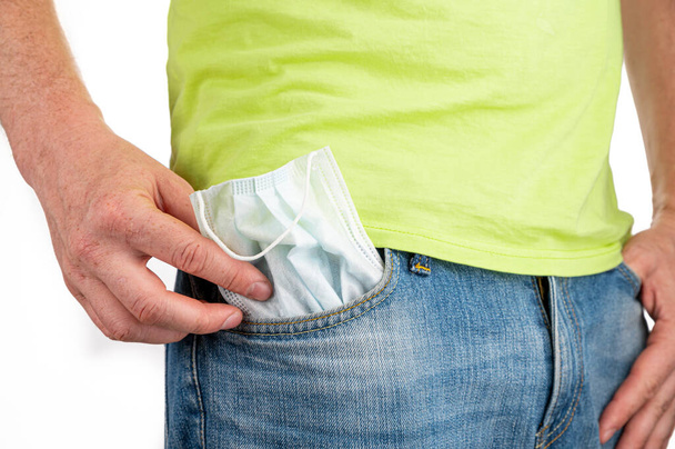 Man take out the medical mask from the front pocket of jeans - Foto, imagen