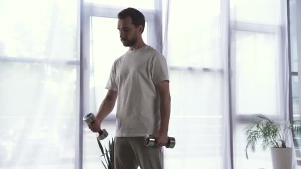 Hombre barbudo entrenando con pesas en casa  - Metraje, vídeo