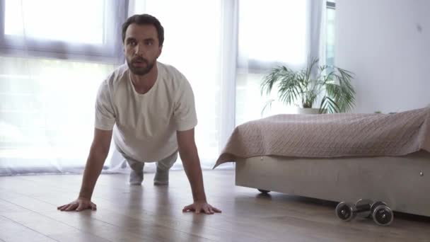 Férfi csinál préselés közelében súlyzók a hálószobában  - Felvétel, videó