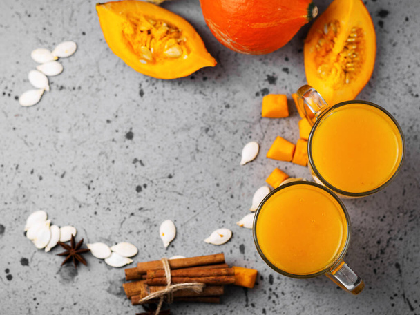 Fresh pumpkin juice smoothie on the table with slices of pumpkin, sunflower seeds, cinnamon - Φωτογραφία, εικόνα
