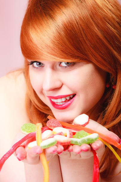 Redhair girl holding sweet food jelly candy on pink. - Valokuva, kuva