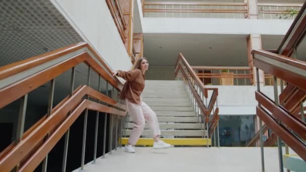 Νεαρή γυναίκα χορεύει στις σκάλες κοντά στο Balustrade - Πλάνα, βίντεο