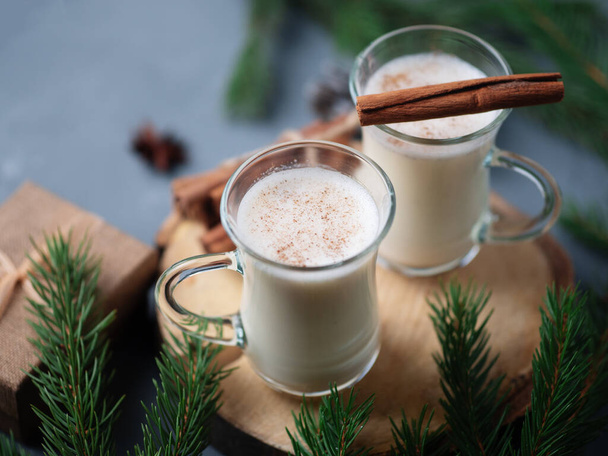 Traditional winter and Christmas drink egg nog in beautiful glass cups on the table with cinnamon - Fotó, kép