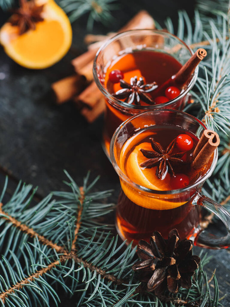 Χειμωνιάτικο ζεστό ρόφημα Χριστουγεννιάτικο ζεστό κρασί σε ποτήρια με γλυκάνισο, κανέλα και μανταρίνι - Φωτογραφία, εικόνα