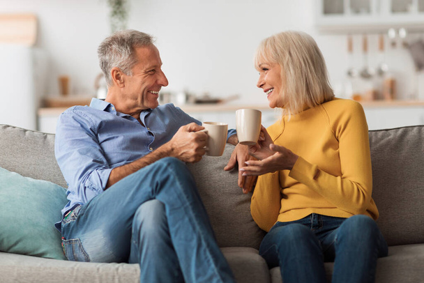 Cheerful Mature Couple Drinking Tea And Talking Sitting At Home - Foto, Bild