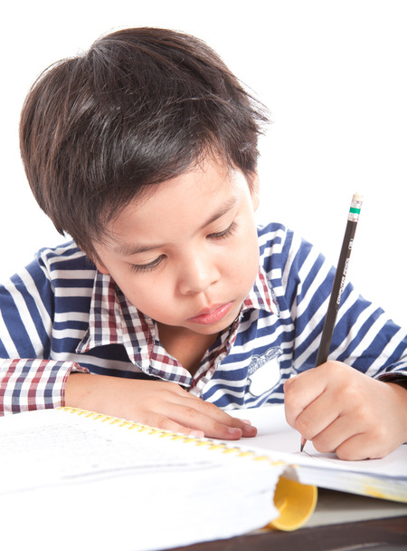 A young boy doing homework on a white background. - 写真・画像