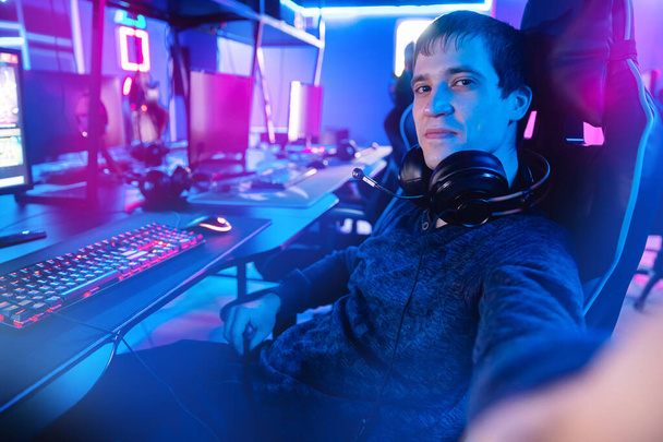Selfie foto feliz jogador profissional homem sorriso jogando torneios online jogos de vídeo computador com fones de ouvido - Foto, Imagem