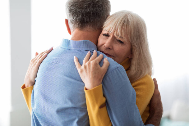 Старшая жена обнимает мужа, утешая и поддерживая его дома - Фото, изображение