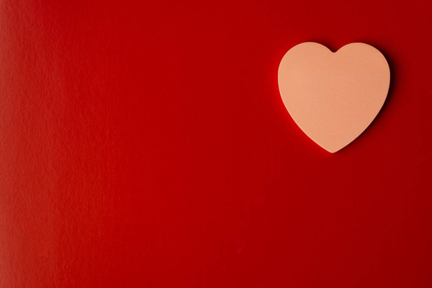Pink heart on red background with copy space. Valentine's day and wedding concept - Фото, зображення