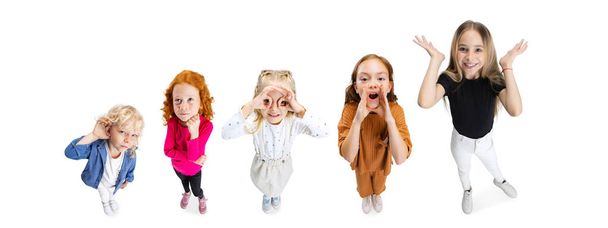 Collage van vier prachtige kinderen, kinderen maken grappige gezichten geïsoleerd over witte achtergrond - Foto, afbeelding