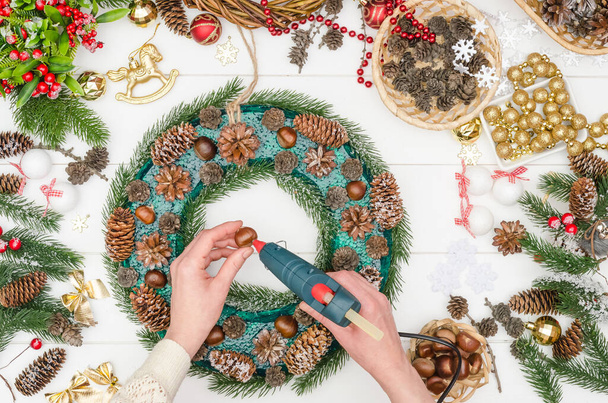 Making a large Christmas wreath step by step, step 10 - glue natural chestnuts with hot glue - Φωτογραφία, εικόνα