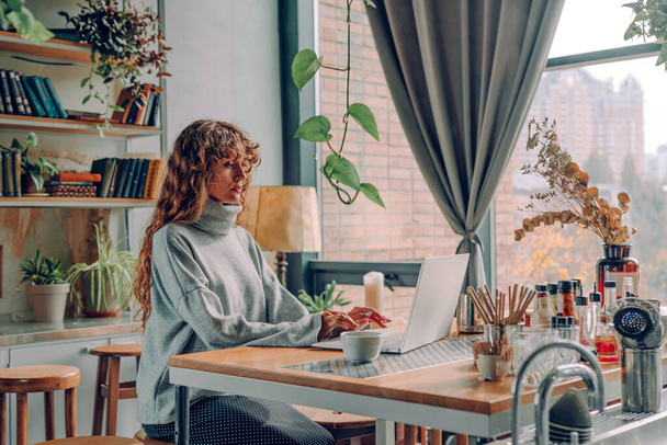 Молодая женщина фрилансер, работающая в винтажном стиле интерьера кафе с помощью ноутбука. Селективный фокус. - Фото, изображение