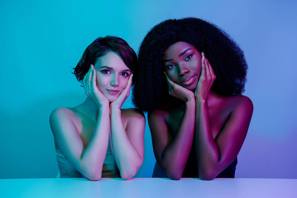 Muotokuva kaksi onnellista viehättävä tyttöystäviä kädet posket puhdas esteettinen eristetty neon vaalea tausta - Valokuva, kuva