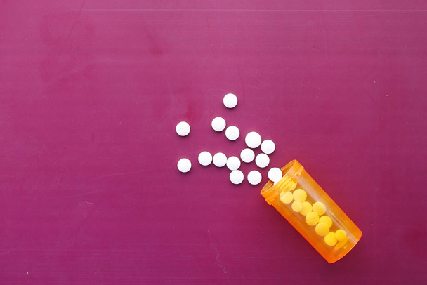  pillole mediche di colore bianco versando sul rosa  - Foto, immagini