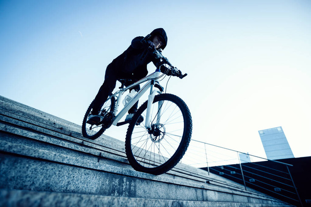 Woman freerider riding bike down city stairs - Zdjęcie, obraz