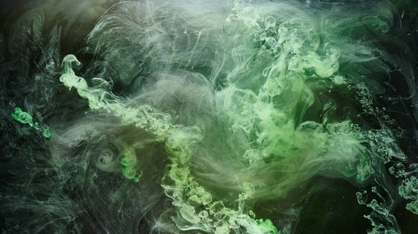 Green smoke on black ink background, colorful fog, abstract swirling emerald ocean sea, acrylic paint pigment underwater - Фото, изображение