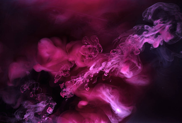 Fumo rosa sobre fundo de tinta preta, nevoeiro colorido, toque abstrato rodopiando mar oceano, tinta acrílica pigmento subaquático - Foto, Imagem