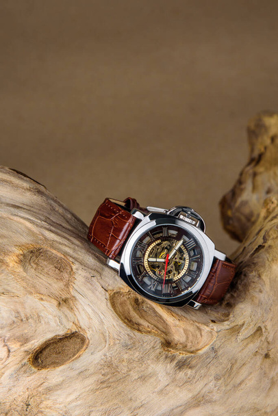 Relógios de pulso homem de luxo colocados em madeira isolada em fundo marrom - Foto, Imagem