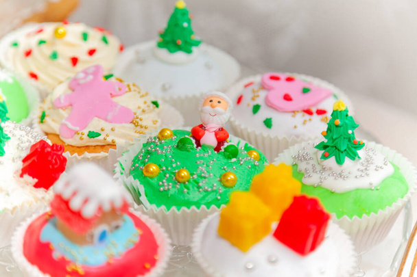 Pasteles caseros, cupcakes, magdalenas decoradas en un estilo navideño. Navidad festiva de temporada mini postre cupcakes en elementos de símbolos decorativos tradicionales - Foto, imagen