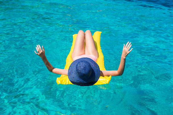 Женщина отдыхает на надувном матрасе в море
 - Фото, изображение