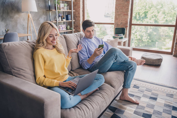 Portrait of attractive cheerful couple using gadget laptop watching video pastime at home loft industrial interior indoors - Φωτογραφία, εικόνα