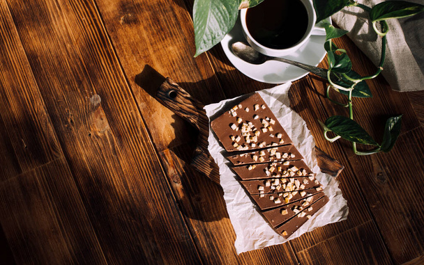 egészséges természetes csokoládé és csésze kávé fából készült háttér - Fotó, kép