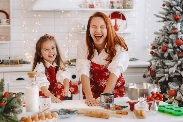 Mom and daughter in the New Year's kitchen together prepare dough for Christmas cookies. - Foto, Bild