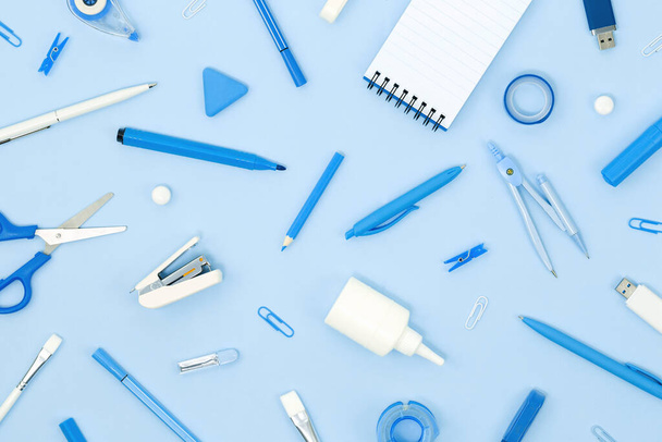 Assorted office and school white and blue stationery and notepad on blue monochrome background. Flat lay knolling with copy space for back to school or education and craft concept. Alarm clock - Foto, Bild