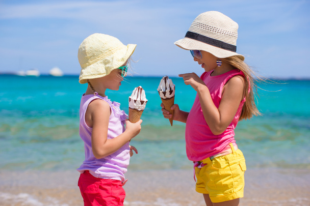Little adorable girls eating ice cream on tropical beach - Photo, Image