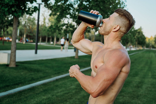 sports muscular man in the park healthy food fitness - Foto, imagen