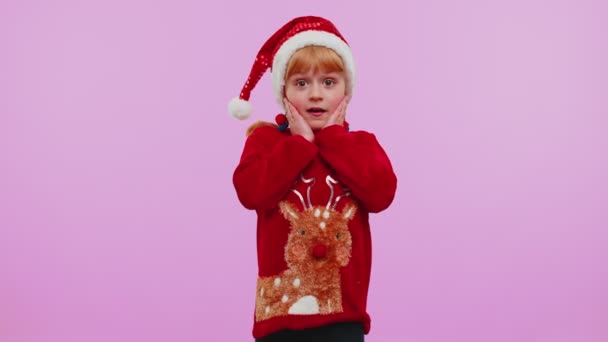 Школа девочка в рождественском свитере поднимает руки в удивлении от внезапной победы, ничего себе эмоции - Кадры, видео
