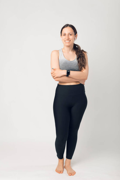 Full height photo of fit young woman, posing at camera with folded hands - Φωτογραφία, εικόνα