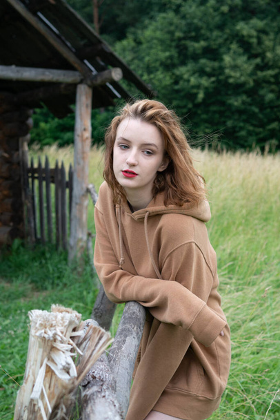 portrait of a girl in the village outside in a sweater in the summer in the field - Foto, Imagem