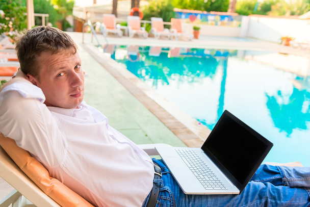 Красивый молодой бизнесмен отдыхает у бассейна
 - Фото, изображение