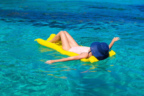 Mujer relajándose en colchón inflable en el mar
 - Foto, imagen