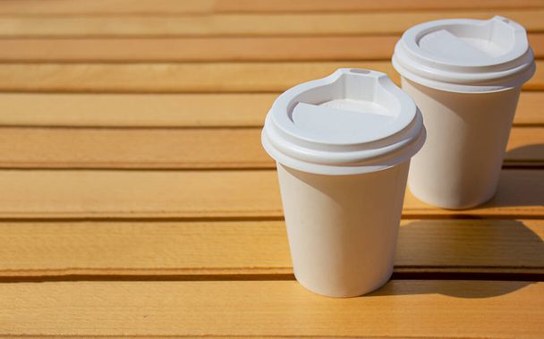 Паперові чашки з кавою на дерев'яному фоні. Концепція вуличної їжі. Копіювати простір
 - Фото, зображення