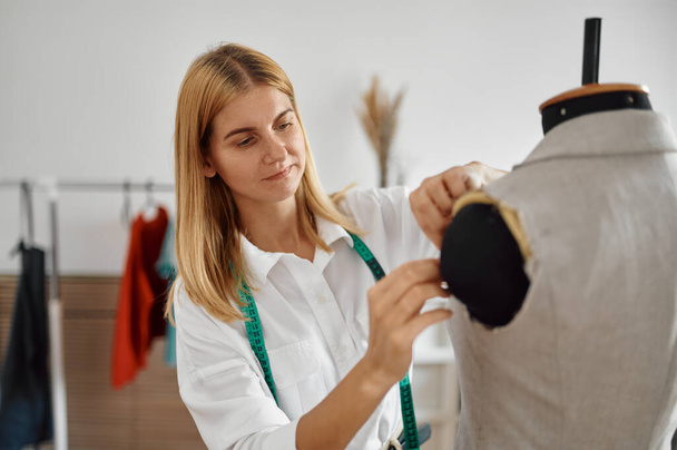 Dressmaker intenta en vestido en maniquí, taller - Foto, Imagen