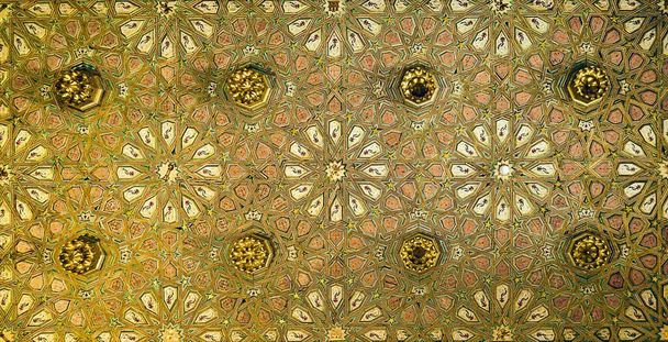 Oude plafond van een moskee in Sevilla (Spanje) vormen bloemblaadjes van verschillende kleuren en goud. - Foto, afbeelding