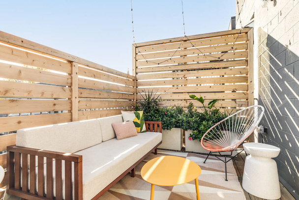 CHICAGO, IL, USA - NOVEMBER 5, 2020: A small outdoor patio in a city condo surrounded by a wooden fence. The patio has cozy furniture and plants to fill the space. - Photo, Image