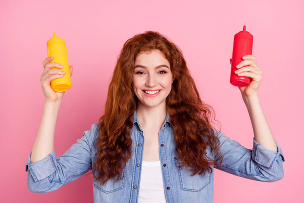 Photo of happy cheerful young nice lady hold hands bottle ketchup mustard isolated on pink color background - Foto, immagini
