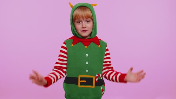 Chica confusa en traje de Navidad sintiéndose avergonzado acerca de la pregunta ambigua que tiene duda ni idea - Metraje, vídeo