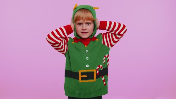 Dziewczyna dziecko Boże Narodzenie Elf zakrywając uszy i gestykulując nie, unikając porady ignorując nieprzyjemny hałas - Materiał filmowy, wideo