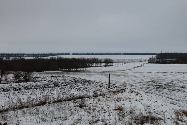 Зимове сільськогосподарське поле під снігом і похмура погода
 - Фото, зображення
