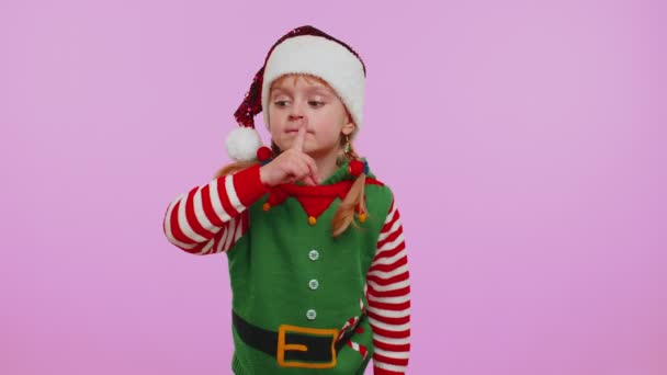 Bambino ragazza in costume Elfo Natale preme indice dito alle labbra fa segno gesto di silenzio, segreto - Filmati, video