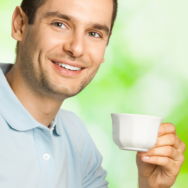 ευτυχισμένος χαμογελαστός άνθρωπος πίνει καφέ, σε εξωτερικούς χώρους - Φωτογραφία, εικόνα