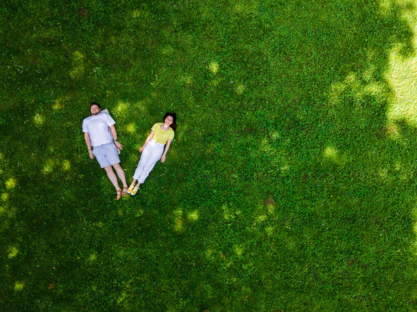 sorridente coppia sdraiata su erba verde copia spazio - Foto, immagini