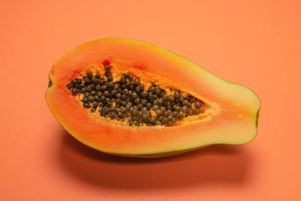 Papaya fruit on a orange background. Tropical fruit. Half papaya.  - Photo, Image