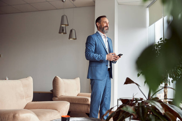 Happy adult caucasian man is working in a modern office - Foto, afbeelding