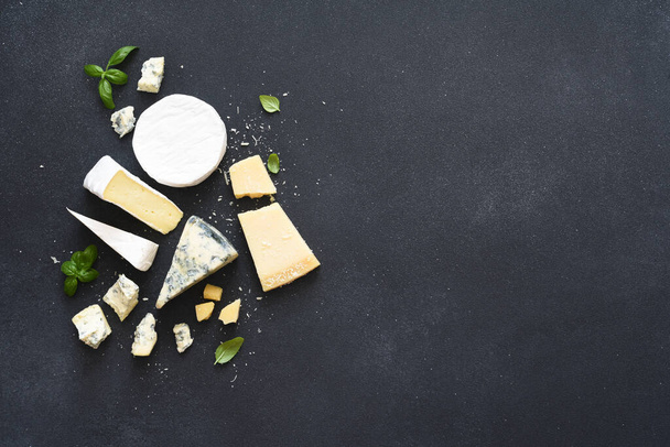 Set of cheeses: blue mold, parmesan, brie on a concrete black background. - Foto, Imagen