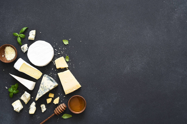 Set of cheeses: blue mold, parmesan, brie on a concrete black background. - Fotó, kép